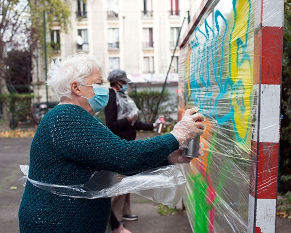 Des voisines venues spécialement pour l’occasion découvrent la peinture sur cellophane. « Le quartier s’habille de couleurs et de joie », estime l’une d’elles.