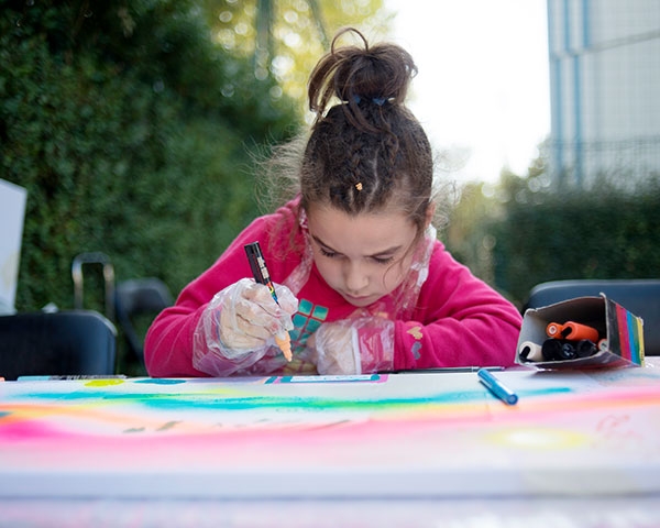La petite Carmen, très concentrée, exprime ses talents d’artiste sur la toile.